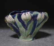 Small pottery vessal with white tulips on a blue background. 